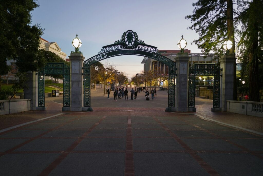 a group of people walking down a street under an arch